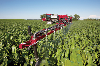 Red sprayer floater in a field of corn spraying crop proctection products.
